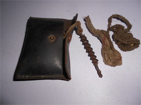 A RIFLE PULL THROUGH IN A LEATHER POCKET SATCHEL